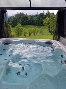 Una bañera de hidromasaje con vista a un campo. en Grafbauer, en St. Wolfgang