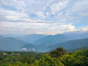 a view of a valley with mountains and trees at Valley Mist rooms & kitchen in Ravangla