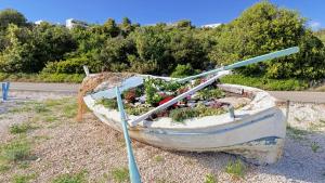 a boat with plants in it sitting on the side of a road at Vila Ivana Dolores in Vinišće