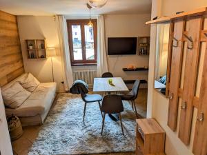 a living room with a table and chairs and a couch at Cozy & Modern Lodge in Bocenago