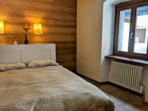 a bedroom with a bed and a window at Cozy & Modern Lodge in Bocenago