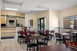 a restaurant with tables and chairs and a kitchen at Super 8 by Wyndham Santa Rosa in Santa Rosa