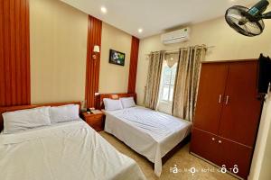 a bedroom with two beds and a tv in it at Bảo Ngọc Cô Tô hotel in Dao Co To