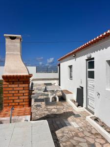 un patio con mesa de picnic y un edificio en Ninho da Praia, en Baleal
