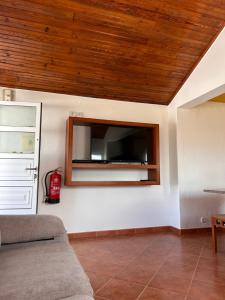 Una sala de estar con un televisor de pantalla plana en la pared. en Ninho da Praia, en Baleal