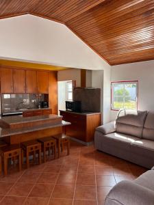 Una sala de estar con un sofá y una cocina. en Ninho da Praia, en Baleal