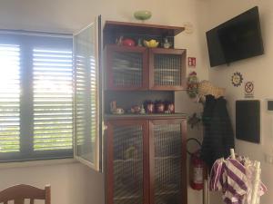 a living room with a cat cage and a television at Villetta SCHIRÒ - BAGNASCO in Campofelice di Roccella
