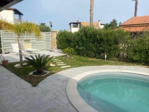 a swimming pool in a yard next to a house at Villetta SCHIRÒ - BAGNASCO in Campofelice di Roccella