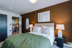 a bedroom with a large bed with a green blanket at Leeds City Centre - HIGH SPEC!! Stunning 2 Bedroom Apartment BRAND NEW!! in Beeston Hill