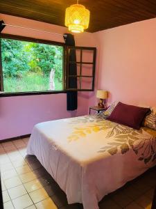 a bedroom with a large bed and a window at By Jess in La Foa