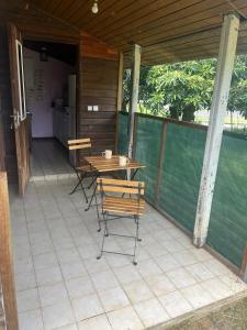 a patio with a table and chairs on it at By Jess in La Foa