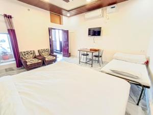 a hospital room with two beds and a table at LD Guest House, Ayodhya in Ayodhya