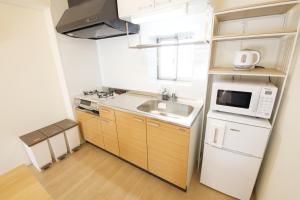a small kitchen with a sink and a microwave at Li Kotohogi 4F,5F in Naha