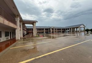 Un estacionamiento vacío frente a un edificio en Days Inn by Wyndham Navasota, en Navasota