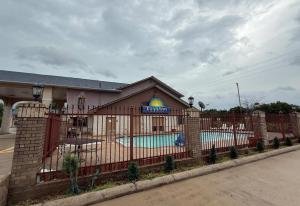 un edificio con valla y piscina en Days Inn by Wyndham Navasota, en Navasota
