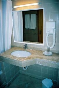 a bathroom with a sink and a mirror at Areia Dourada in Porto Santo