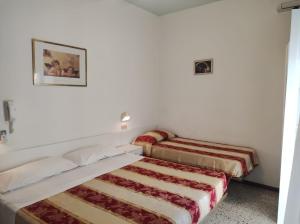 two beds in a room with a picture on the wall at Hotel Diana in Misano Adriatico