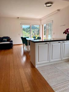 a living room with a kitchen and a table with chairs at Luxury Villa Kadic in Bjelašnica +93 photos