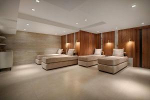 La Quinta by Wyndham Batumi في باتومي: غرفة معيشة بها كنبتين وجدران خشبية +36 صورة