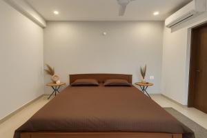 a bedroom with a large bed and two tables at Shelbys Abode in Dehradun