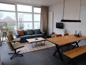 a living room with a blue couch and a table at Marina Strandbad Chalet SunnyTides Haus Nr 36 in Olburgen