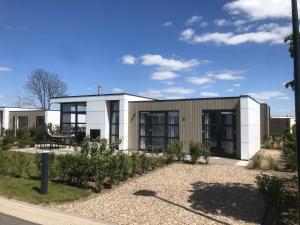a large white building with a lot of windows at Marina Strandbad Chalet SunnyTides Haus Nr 36 in Olburgen