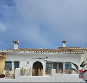 a white building with a sign that reads car us broker at Casa la Baouzza in Cumbre del Sol