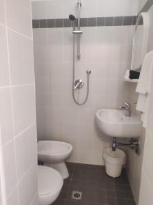 a white bathroom with a sink and a toilet at Hotel Diana in Misano Adriatico