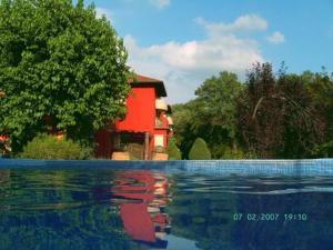 a house and a swimming pool with a red house at Hotel Torre Marti in Sant Juliá de Vilatorta