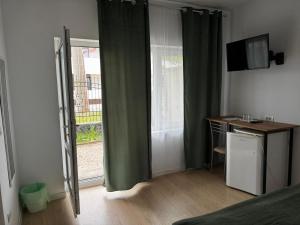 a room with a bed and a desk and a window at Vila Happy House in Costinesti