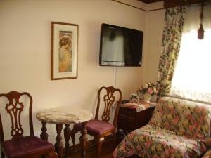 a living room with two chairs and a table and a tv at Victoriański 15 & Antyczny 16 in Kazimierz Dolny