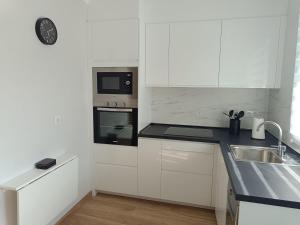 a white kitchen with a sink and a microwave at Concepción Arenal in Ferrol