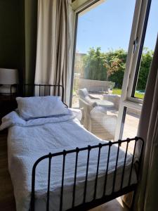 a bedroom with a bed in front of a window at Castletroy Retreat in Limerick