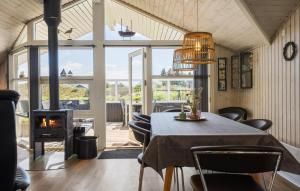 a dining room with a table and a fireplace at Holiday Home Bjerregårdsvej Hvide Sande in Bjerregård