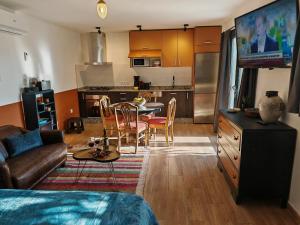 une cuisine et un salon avec un canapé et une table dans l'établissement Los Nopalitos 1 -Estudio chulísimo súper equipado a 3,5km de Carboneras, à El Llano de Don Antonio