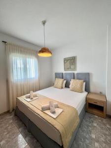 a bedroom with a bed with two towels on it at Maison Ciel in Agia Paraskevi