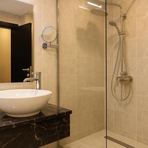 bagno con lavandino e doccia in vetro di Saraya Palace Hotel a Doha