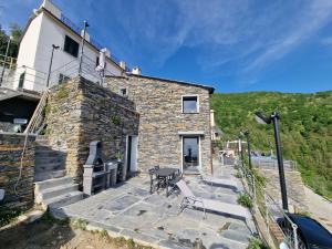 a stone house with a table and chairs in front of it at Dimore d'Oltremare - Appartamento Libeccio in Lavagna