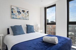 a bedroom with a large bed with blue pillows at Luxurious 2 bed city centre apartment!!! in Birmingham