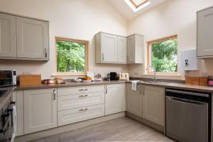 a kitchen with white cabinets and a window at Vesta View & Shepherds Retreat in Hexham