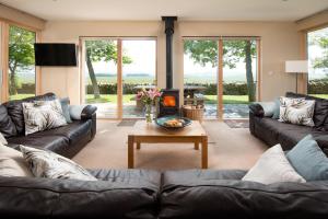 a living room with couches and a table and a fireplace at Vesta View & Shepherds Retreat in Hexham