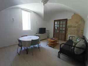 a living room with a table and chairs and a window at Dans maison de maître, appartement indépendant. in Montfrin