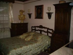 a bedroom with a bed and a dresser and a statue at Victoriański 15 & Antyczny 16 in Kazimierz Dolny