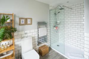 a white bathroom with a tub and a toilet at Contemporary 5 Bedroom with Garden North Finchley in London +26 photos