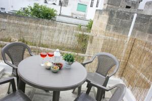 Una mesa con dos copas de vino en un balcón. en Casetta la Farfalla - Accogliente appartamento a pochi minuti dal mare, en Manduria