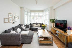 a living room with two couches and a tv at Contemporary 5 Bedroom with Garden North Finchley in London