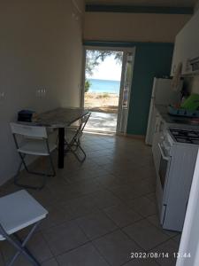 a kitchen with a table and a view of the ocean at House on the wave relax in Koroni +41 photos