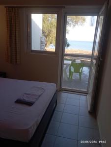 a bedroom with a bed and a view of the ocean at House on the wave relax in Koroni