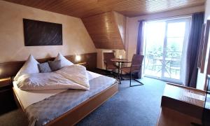 a hotel room with a bed and a large window at Hotel Klett B&B in Langenargen