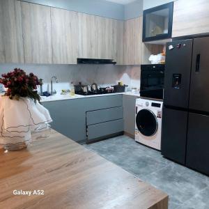 una cucina con lavatrice e lavatrice di French village two a Duhok